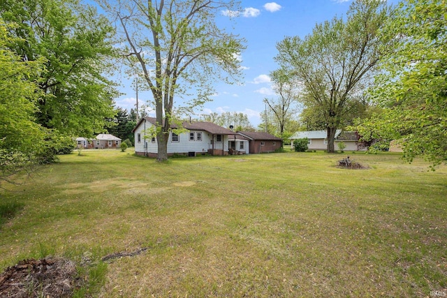 view of green lawn with an outdoor fire pit
