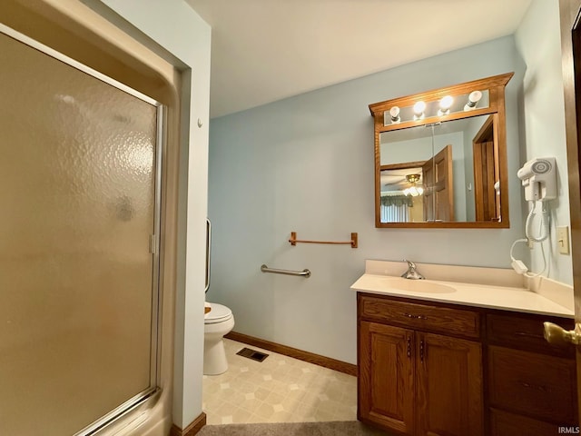 bathroom featuring a shower stall, vanity, baseboards, tile patterned floors, and toilet