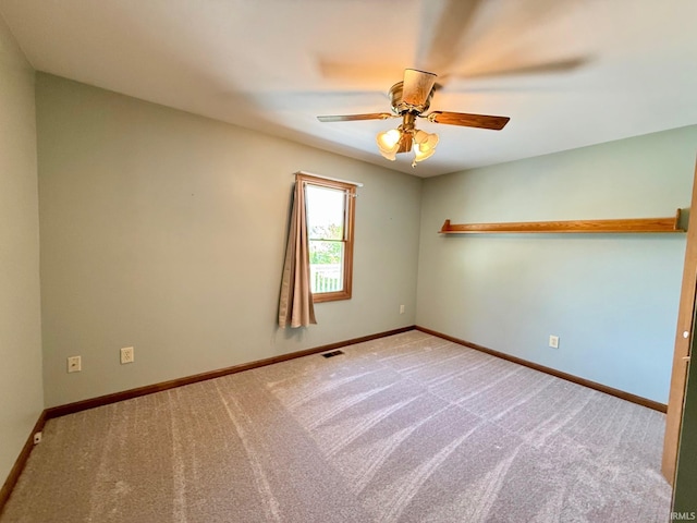 spare room featuring a ceiling fan, carpet floors, and baseboards