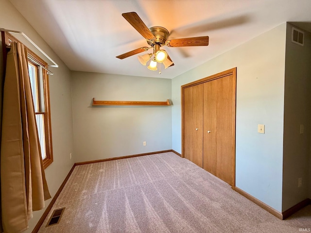 unfurnished bedroom with a closet, carpet, baseboards, and ceiling fan