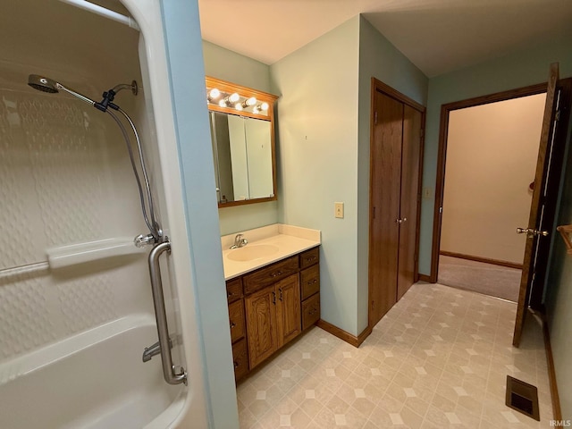 full bath featuring a shower, vanity, and baseboards