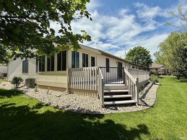 rear view of house with central air condition unit, a yard, and a wooden deck