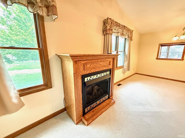 unfurnished living room with light carpet, a fireplace, lofted ceiling, baseboards, and a chandelier