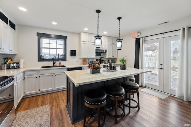 1308 Tedlee Dr, Kokomo, IN 46901 - kitchen featuring a sink, white cabinetry, a kitchen breakfast bar, electric range, and recessed lighting