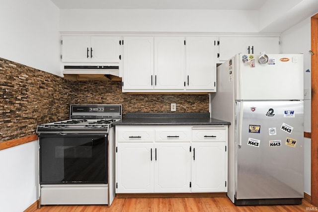 3430 Woodrow Ave, Fort Wayne, IN 46805 - kitchen with gas range, freestanding refrigerator, under cabinet range hood, dark countertops, and white cabinets