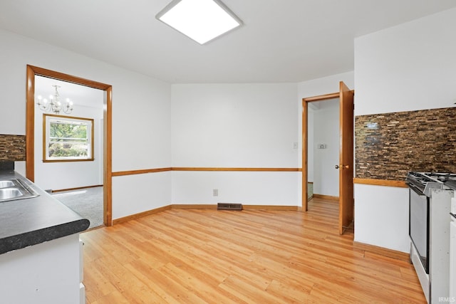 3430 Woodrow Ave, Fort Wayne, IN 46805 - kitchen featuring gas stove, light wood-style floors, a chandelier, and dark countertops