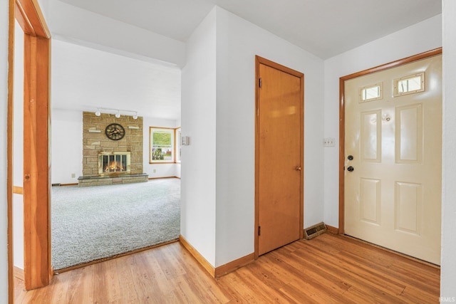 3430 Woodrow Ave, Fort Wayne, IN 46805 - entrance foyer featuring light wood-type flooring, baseboards, rail lighting, and a stone fireplace