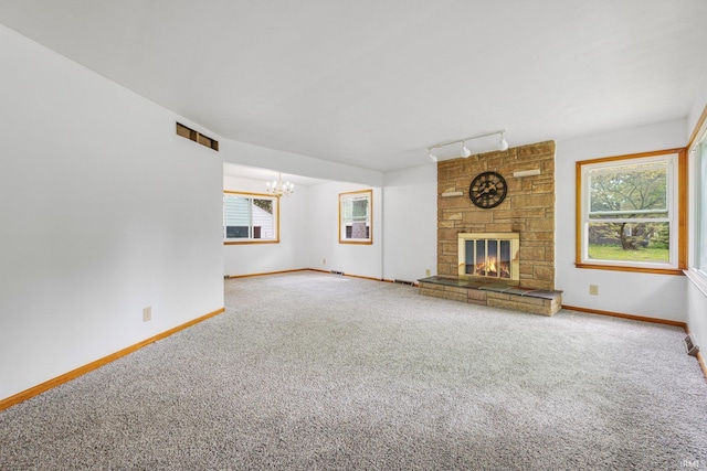 3430 Woodrow Ave, Fort Wayne, IN 46805 - unfurnished living room with carpet, track lighting, a chandelier, baseboards, and a large fireplace