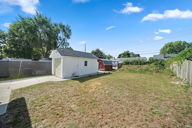 view of yard with an outbuilding, driveway, and a shed