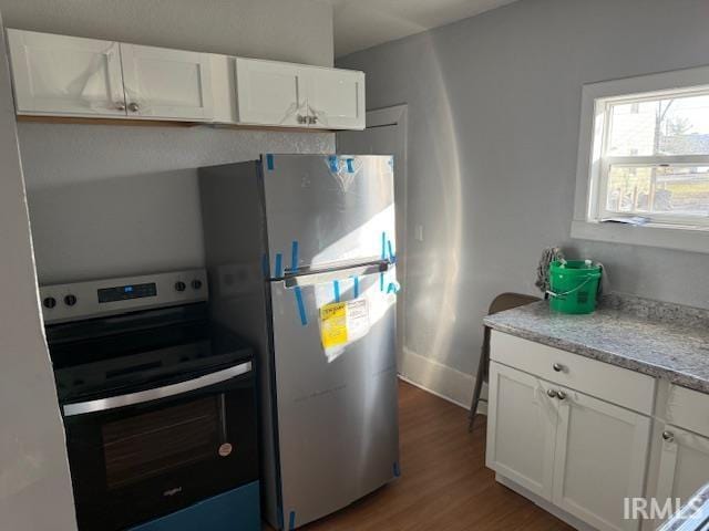 1710 Sibley Ave, South Bend, IN 46628 - kitchen with appliances with stainless steel finishes, wood finished floors, white cabinets, and light stone counters