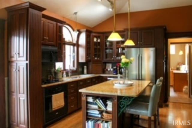 127 W Mill St, Bremen, IN 46506 - kitchen with black appliances, lofted ceiling, pendant lighting, a sink, and glass insert cabinets