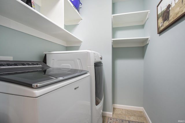 clothes washing area featuring washer and dryer and baseboards