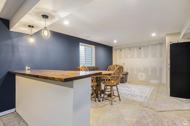 bar with recessed lighting, hanging light fixtures, and concrete flooring