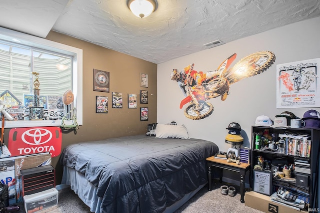 carpeted bedroom featuring a textured ceiling