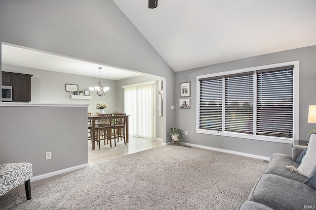 carpeted living area featuring a chandelier, baseboards, and high vaulted ceiling