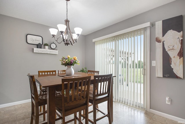 dining room with baseboards and a chandelier