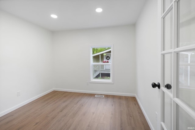 unfurnished room featuring wood finished floors, baseboards, and recessed lighting