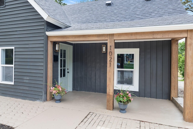 entrance to property featuring a shingled roof