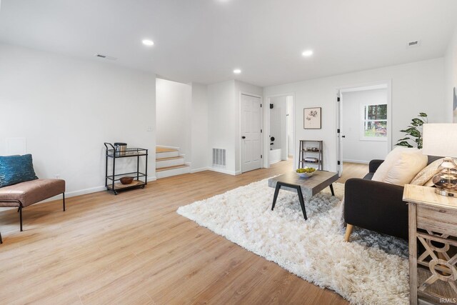 living area featuring stairs, light wood-type flooring, baseboards, and recessed lighting