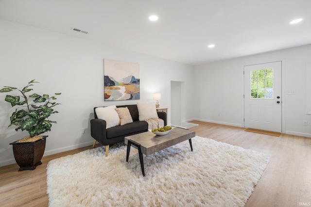 living room featuring light wood finished floors, baseboards, and recessed lighting