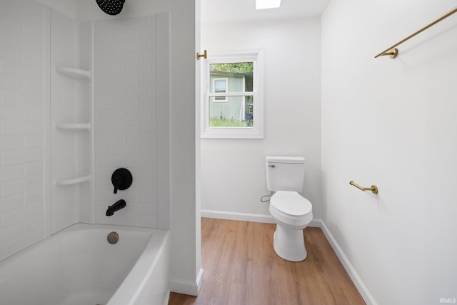 bathroom featuring wood finished floors, toilet, baseboards, and shower / bathtub combination