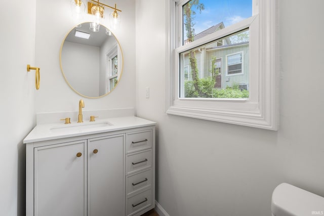 bathroom featuring plenty of natural light, vanity, and toilet