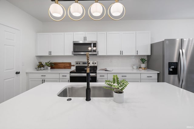 kitchen featuring stainless steel appliances, light countertops, and white cabinetry