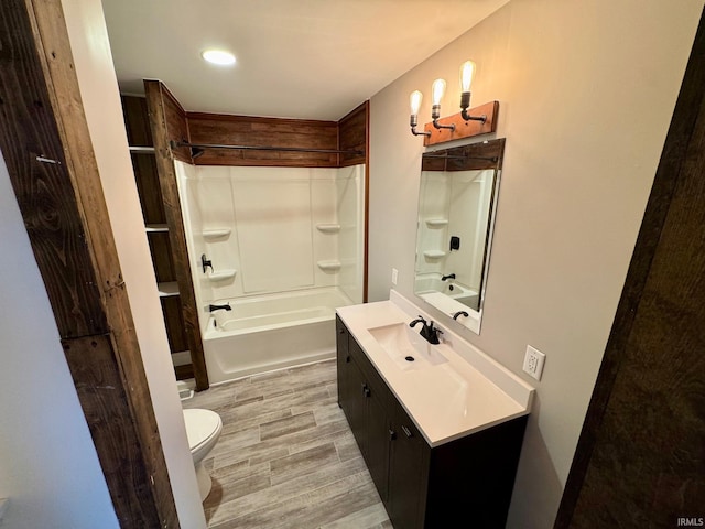 full bath with toilet, vanity, bathtub / shower combination, wood finished floors, and recessed lighting