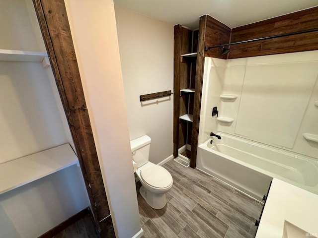 bathroom featuring toilet, wood finished floors, and tub / shower combination