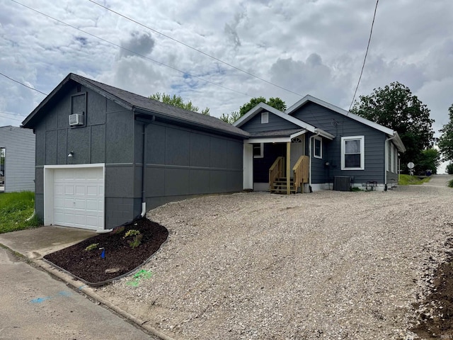view of front of home featuring a garage, central AC unit, and driveway