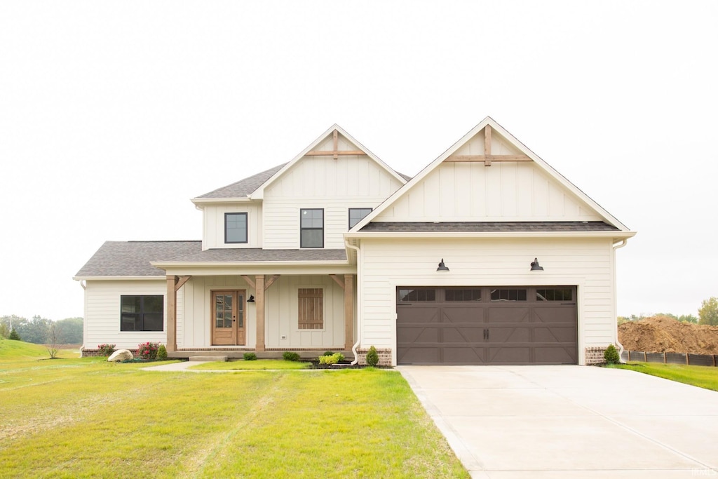 modern inspired farmhouse featuring board and batten siding, a front lawn, driveway, and a garage