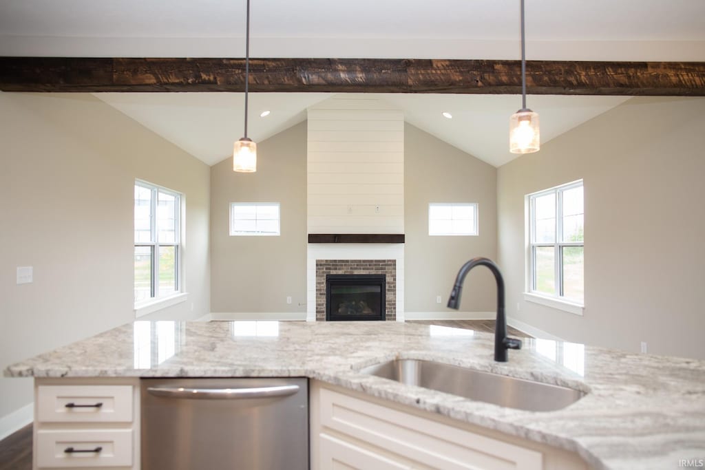 kitchen with dishwasher, a sink, light stone countertops, white cabinetry, and healthy amount of natural light