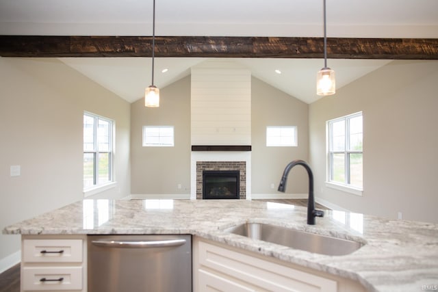 kitchen with dishwasher, a sink, light stone countertops, white cabinetry, and healthy amount of natural light
