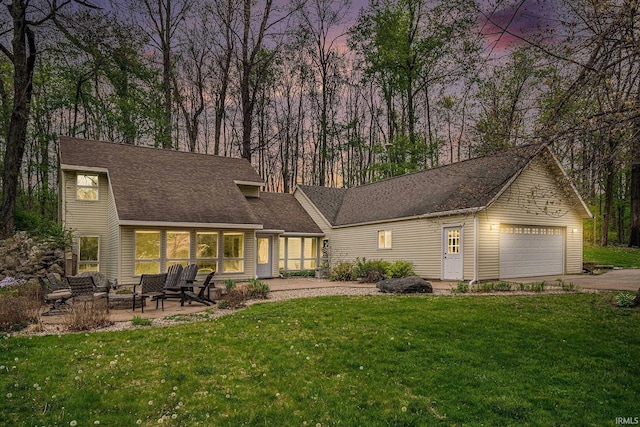 5480 E 900 N, Syracuse, IN 46567 - rear view of house with asphalt driveway, a lawn, an attached garage, and a patio