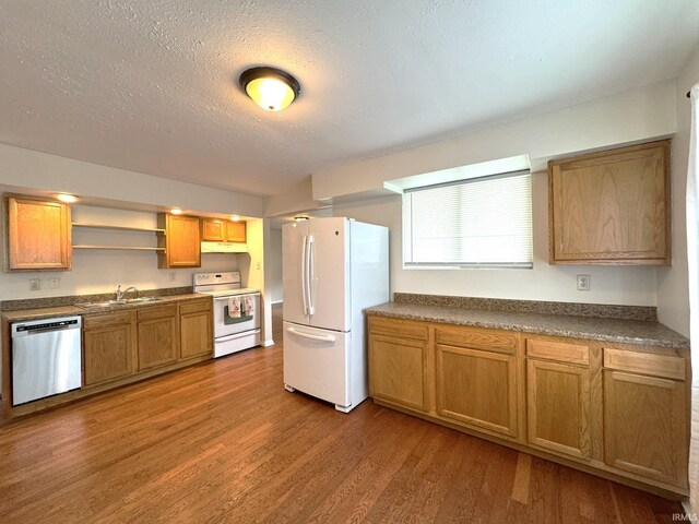 819 N Mccann St, Kokomo, IN 46901 - kitchen with white appliances, a sink, under cabinet range hood, wood finished floors, and dark countertops
