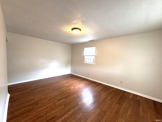 819 N Mccann St, Kokomo, IN 46901 - empty room with a textured ceiling, dark wood-style flooring, and baseboards