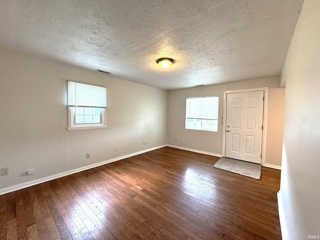 819 N Mccann St, Kokomo, IN 46901 - unfurnished room featuring a textured ceiling, dark wood-type flooring, and baseboards