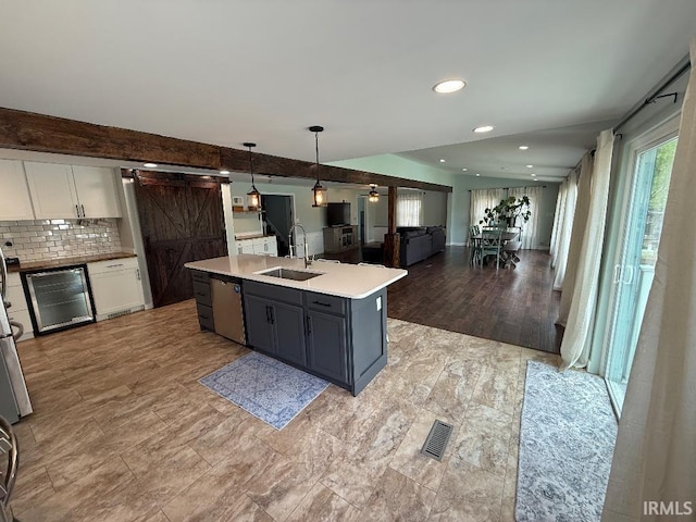 kitchen with a sink, stainless steel dishwasher, wine cooler, a barn door, and open floor plan