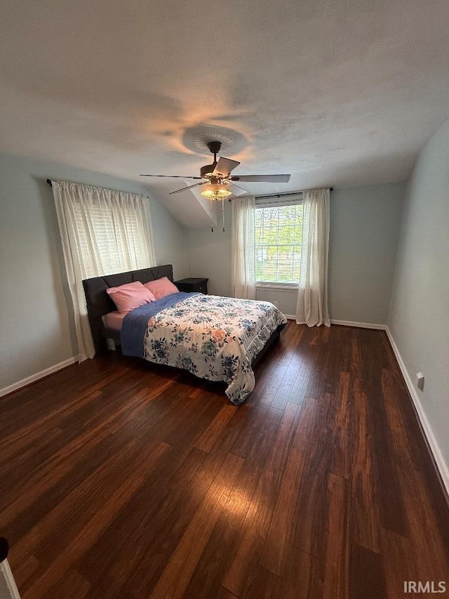 bedroom featuring dark wood-type flooring, baseboards, and a ceiling fan