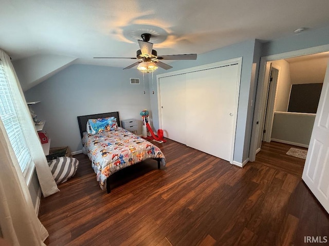 bedroom with wood finished floors, vaulted ceiling, ceiling fan, a closet, and baseboards