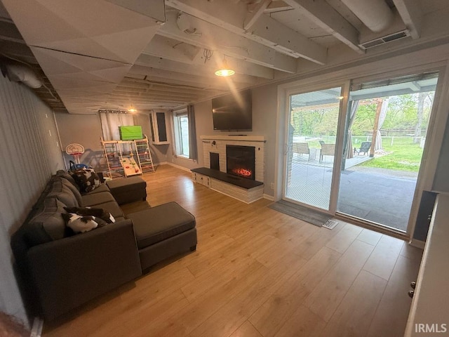 living room with wood finished floors and a brick fireplace