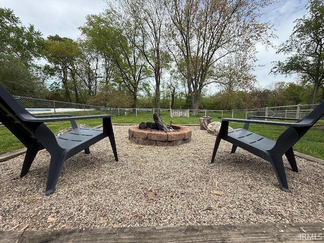surrounding community with fence and an outdoor fire pit