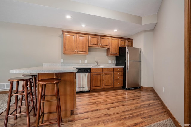 51205 County Road 25th Rd, Bristol, IN 46507 - kitchen featuring appliances with stainless steel finishes, light countertops, light wood-style flooring, a breakfast bar, and recessed lighting
