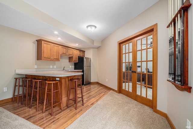 51205 County Road 25th Rd, Bristol, IN 46507 - kitchen with freestanding refrigerator, a kitchen bar, french doors, baseboards, and a peninsula
