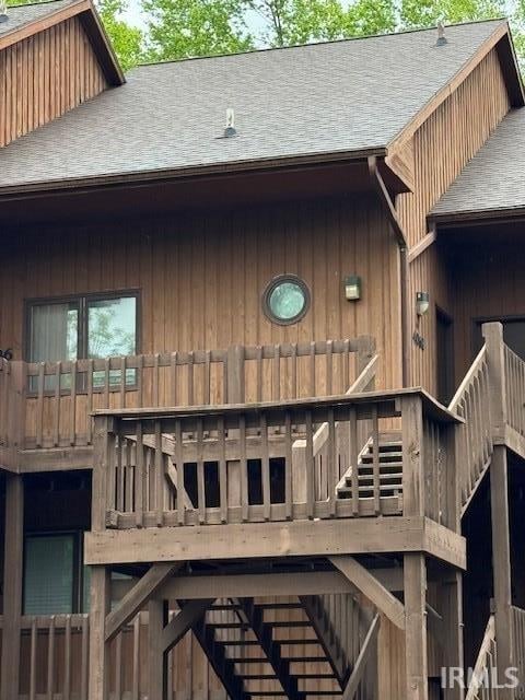 4068 E Eagle Bay Dr Unit 46, Bloomington, IN 47401 - rear view of house with roof with shingles, stairs, a deck, and a chimney