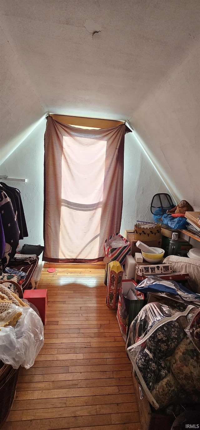 misc room featuring vaulted ceiling and wood-type flooring