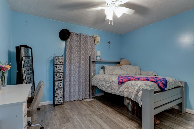 4732 Rathbone Dr, Evansville, IN 47725 - bedroom with wood finished floors, a desk, a textured ceiling, baseboards, and a ceiling fan