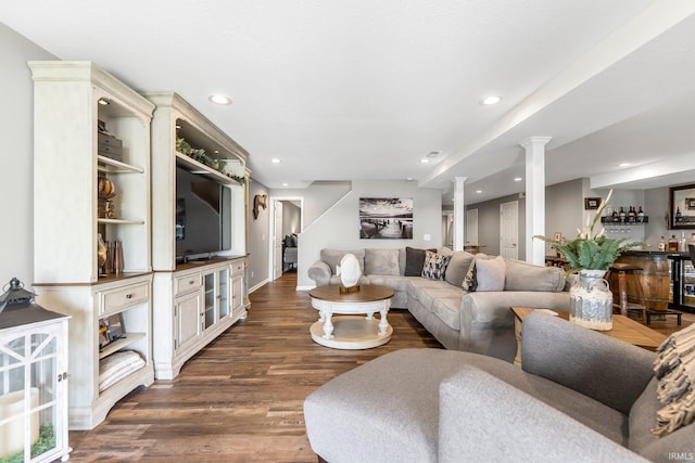 living area with bar area, wood finished floors, recessed lighting, ornate columns, and baseboards