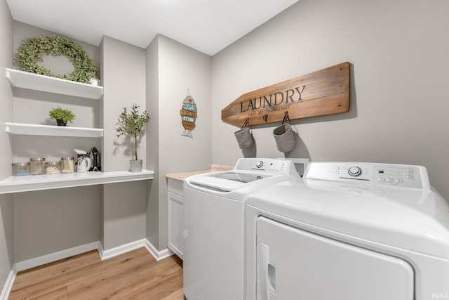washroom with cabinet space, independent washer and dryer, light wood-style flooring, and baseboards