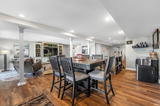 dining space with decorative columns, dark wood-type flooring, baseboards, and recessed lighting